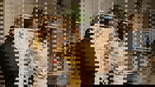 A person in a sewing studio pins some fabric to a design pin board 