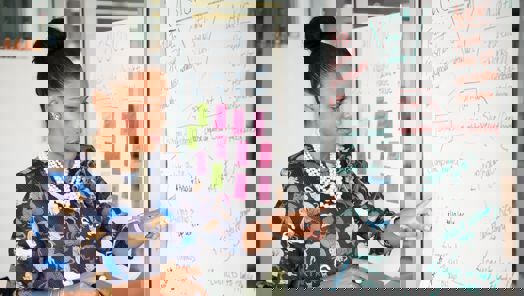 manager pointing at a graphic on a board