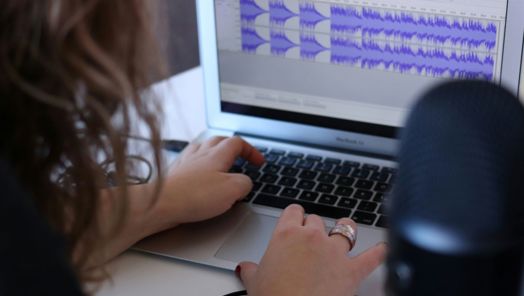Closeup of someone editing some audio tracks in a sound editing software on a computer.