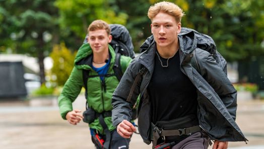 Two contestants on Race Across the World march along the street wearing backpacks