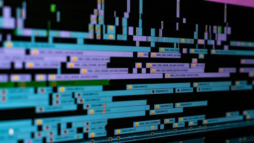 A closeup of a series of video clips on a timeline in a video editing software.