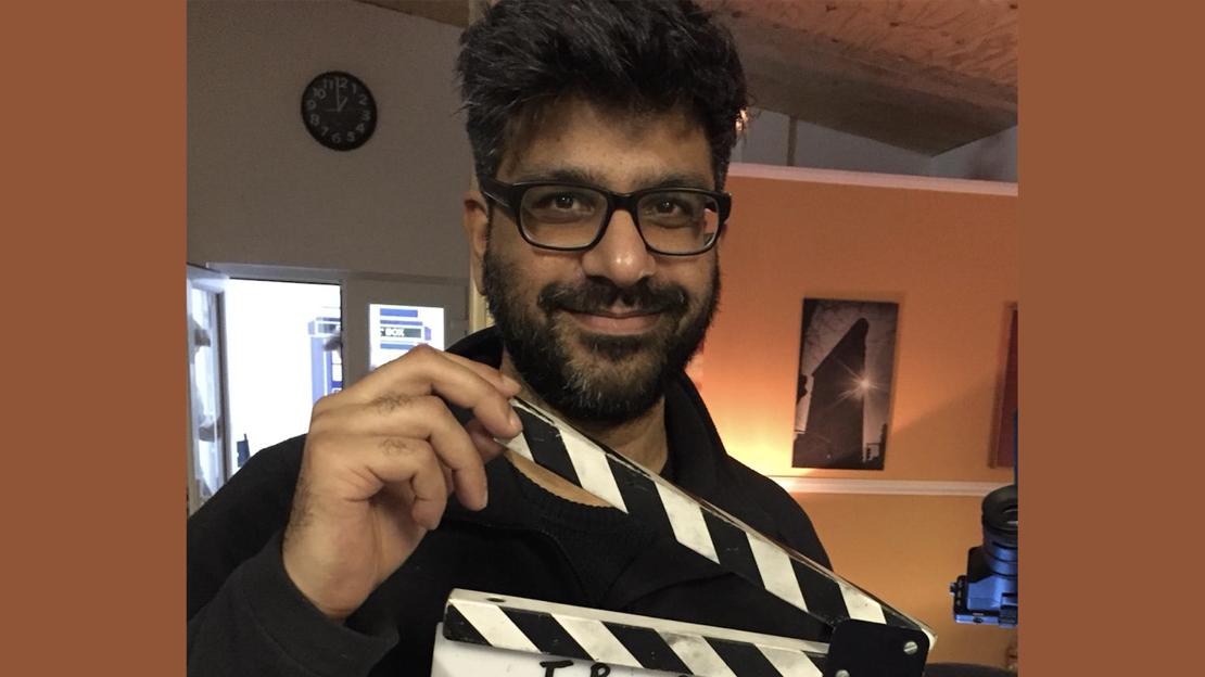 Irshad Ashraf holding a clapper board